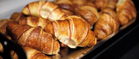 Uma seleção de croissants dourados e crocantes dispostos numa bandeja.
