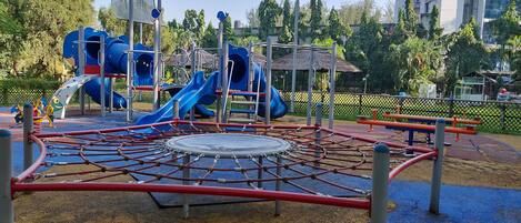 A playground with slides, climbing structures, and a covered play area.