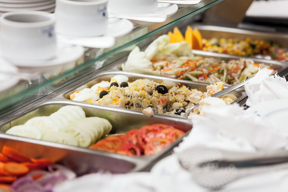 A buffet with various food options including salads, rice dishes, and vegetables.