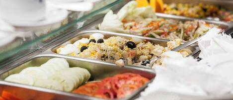 A buffet with various food options including salads, rice dishes, and vegetables.
