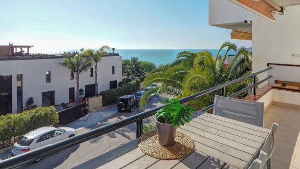 A balcony with a view of the sea, a parked car, and a potted plant. - Balmins White by Hello Homes Sitges (Sitges)