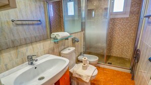 Une salle de bain équipée d’un lavabo, de toilettes, d’un bidet et d’une douche.