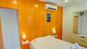 A hotel room with a wooden headboard, a bed with white linens, two bedside tables with lamps, and a wardrobe with a mirror. - Port Alegre Attic by Hello Homes Sitges (Sitges)