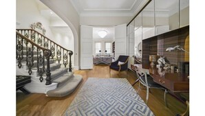 A spacious living area with a staircase, a dining area, and a kitchen. - Magnificent House in Knightsbridge (London)