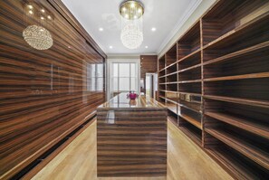 Un intérieur moderne avec des lambris en bois, une table en verre au centre et des étagères intégrées.