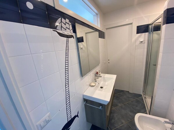 A modern bathroom with a white sink, mirror, and shower. - La Miravè holiday home located in Praiano, jewel of the Amalfi Coast. (Praiano)