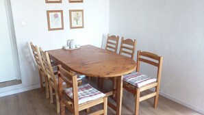 Une table de salle à manger en bois, accompagnée de six chaises, chacune dotée d’un siège rembourré.
