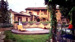 A courtyard with a swimming pool, lounge chairs, and a patio area with outdoor furniture. - Casale Bella Vita 8 4 (Citta della Pieve)