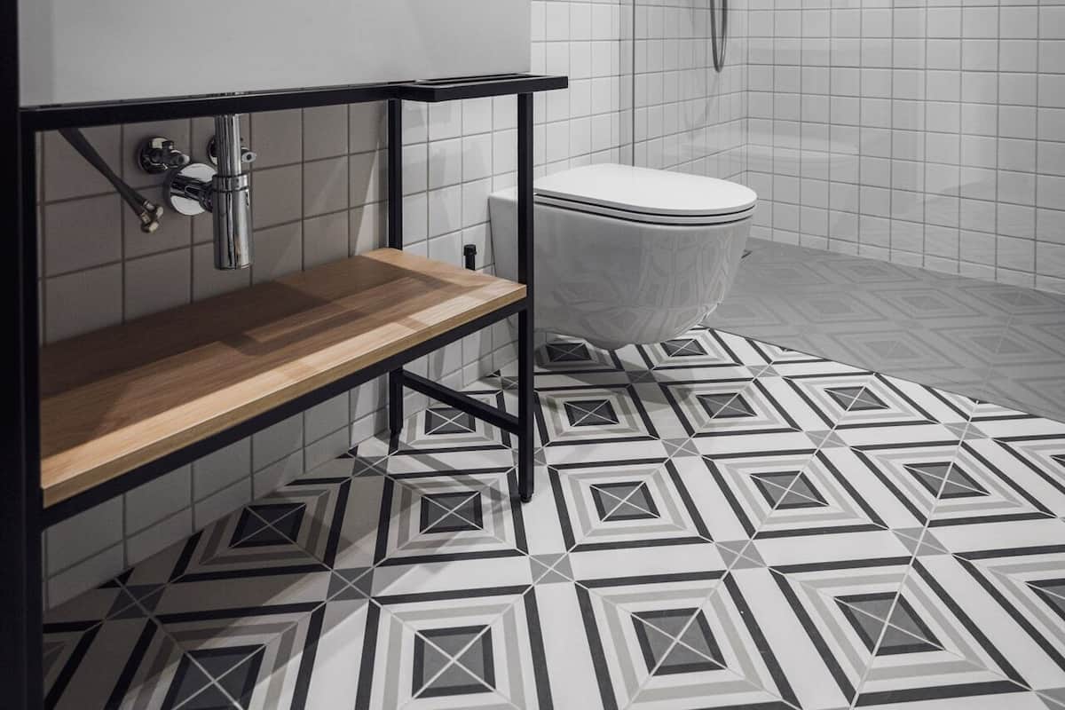 A modern bathroom with a wooden vanity, a white toilet, and a shower area.