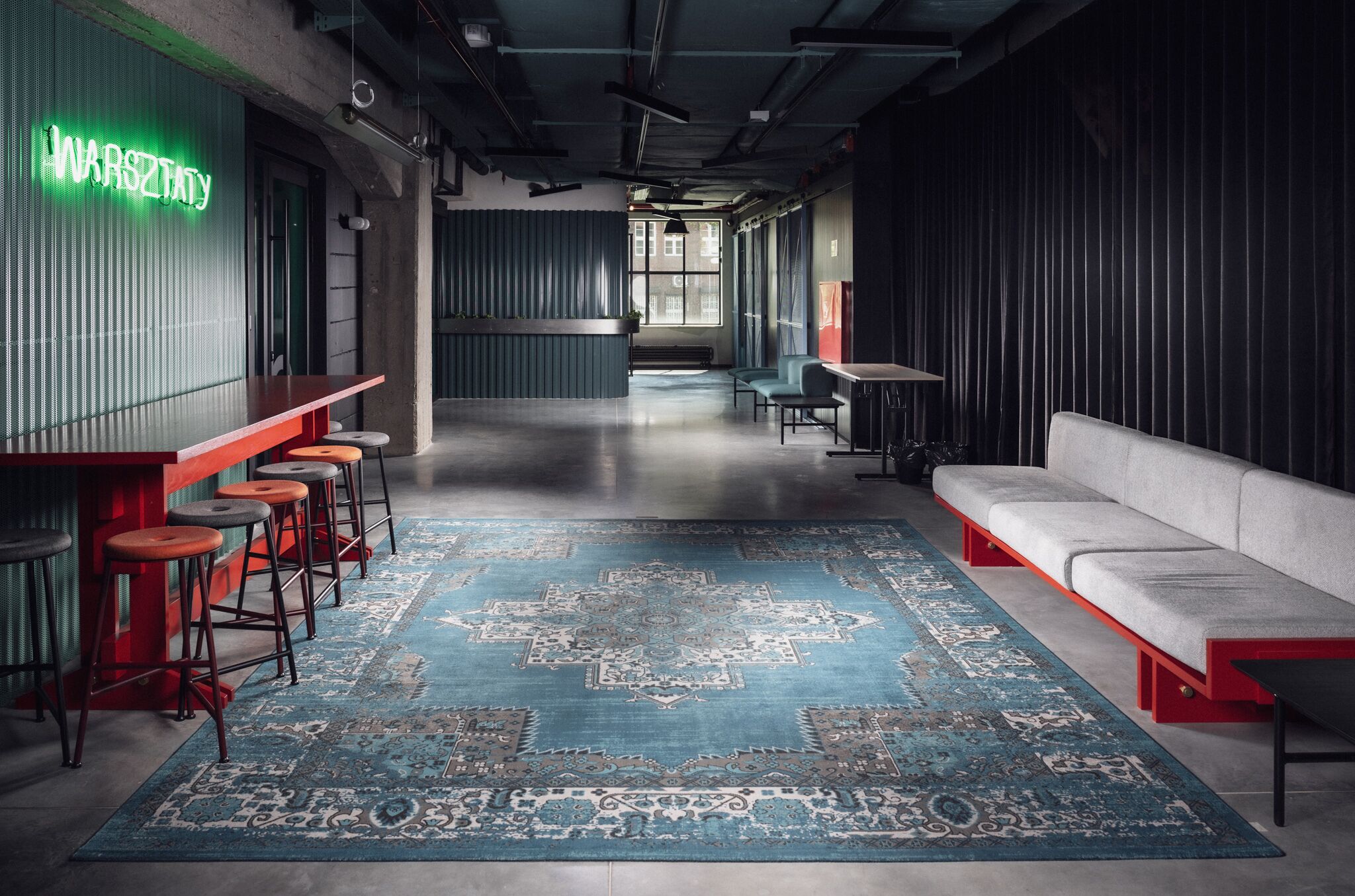 Un intérieur moderne avec un bar, des sièges et un tapis à motifs.