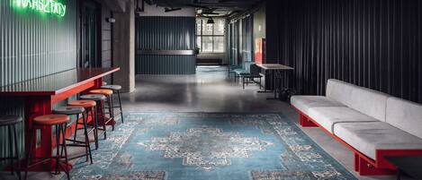 A modern interior with a bar area, seating, and a patterned rug.