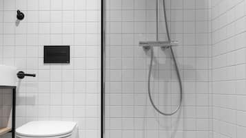 Une salle de bain moderne équipée de toilettes, d’une douche avec une porte en verre et d’un panneau de commande.