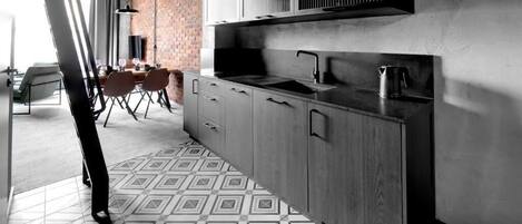 Una cocina moderna con una isla grande, electrodomésticos integrados y un suelo con diseño.