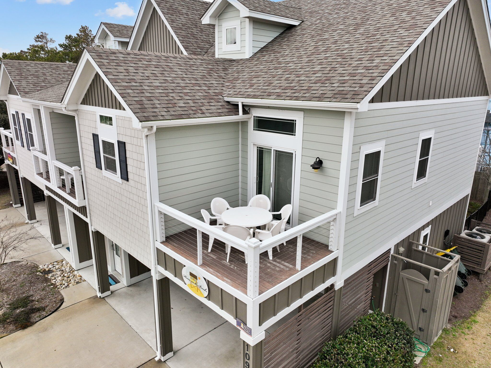 A two-story house with a balcony, a small patio, and a garage.