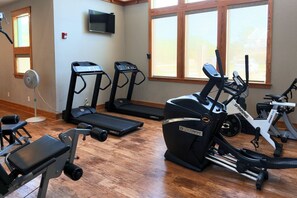 Una palestra con tapis roulant, ellittiche e cyclette.