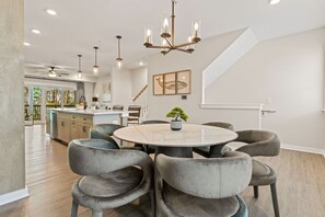Une cuisine moderne dotée d’un îlot central, de luminaires suspendus et d’un escalier menant à un niveau supérieur.
