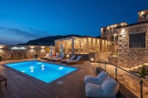 A stone building with a swimming pool, lounge chairs, and a staircase. - Lithoessa Luxury Apartments (Lemnos)