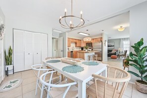 Enjoy meals in this stylish dining area with a table for four, a chandelier, and a fully equipped kitchen.