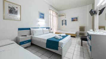 Una habitación de hotel con una cama, un escritorio, una silla y un radiador.