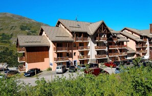 A multi-story hotel with balconies and a parking lot. - 50m from shops, tv, ski locker, 24-28m², Valmeinier (Valmeinier)