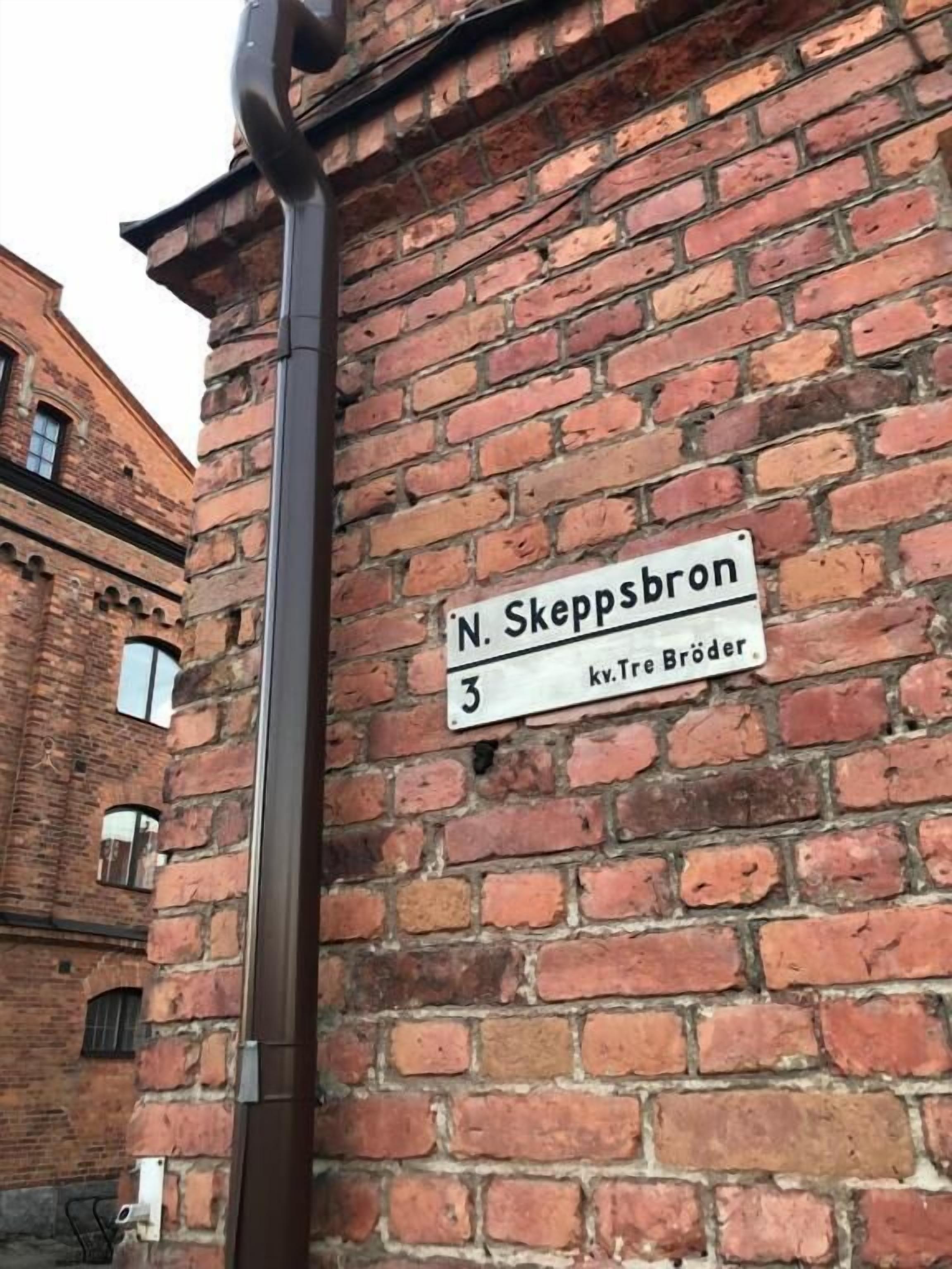 A brick wall with a street sign reading "N. Skeppsbron 3" and "kv. Tre Broder".