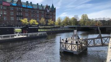Un canal con un muelle de madera y un puente al fondo.
