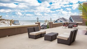 A rooftop patio with wicker furniture, a pool table, and a view of the beach. - Brigantine Beach - 1BR/1BA - Oceanfront property! (Brigantine)