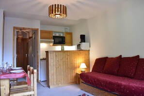 A compact living space with a dining area, a kitchenette, and a sofa. - 100m from resort center, 2nd floor, view mountain, balcony, tv, 24m², Méribel (Méribel - Les Allues)