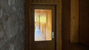 A wooden door leading to a corridor with a stone wall on one side. - 150m from ski slopes, 2nd floor, tv, 37m², Méribel (Méribel - Les Allues)