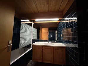 A bathroom with a wooden vanity, a sink, and a mirror. - 150m from ski slopes, 2nd floor, tv, 37m², Méribel (Méribel - Les Allues)