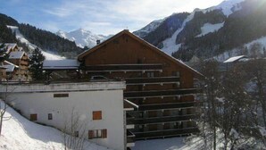 A wooden chalet with a sloped roof, surrounded by snow-covered mountains and a clear sky. - 150m from ski slopes, 2nd floor, tv, 37m², Méribel (Méribel - Les Allues)