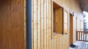 Una cabaña de madera con balcón, una ventana con vistas y una puerta.