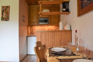 A compact kitchen with wooden cabinets, a microwave, and a coffee maker. - 150m from ski slopes, 3rd floor, balcony, tv, 24m², Méribel (Méribel - Les Allues)