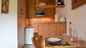 Une cuisine compacte avec des meubles en bois, un four à micro-ondes et une machine à café.