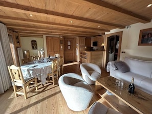Ein Holzinterieur mit Essbereich, Sitzgelegenheiten und einer Couch.