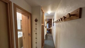 A hallway with wooden doors, a wall-mounted decoration, and a carpeted floor.