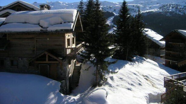 A wooden cabin with a snow-covered roof and a staircase leading up to it. - 300m from shops, 2nd floor, balcony, tv, ski locker, 18m², Méribel (Méribel - Les Allues)