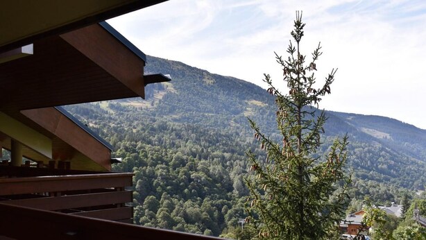 A view from a balcony overlooking a forested mountain landscape. - 200m from ski slopes, 6th floor, swimming pool, tv, ski locker, 50m², Méribel (Méribel - Les Allues)