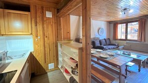 A wooden interior with a kitchen, dining area, and living room.