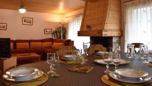 A cozy living room with a wooden ceiling, a fireplace, and a dining area set for a meal. - Ski-in/ski-out & foot of the slopes, balcony, tv, ski locker, 105m², Méribel (Méribel - Les Allues)