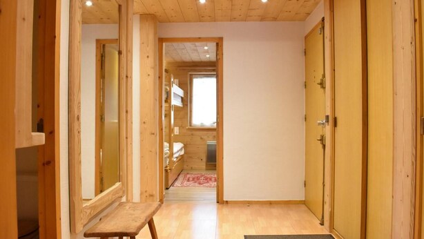 A wooden interior with a bench, a door, and a view into another room. - Ski-in/ski-out & foot of the slopes, balcony, tv, ski locker, 105m², Méribel (Méribel - Les Allues)