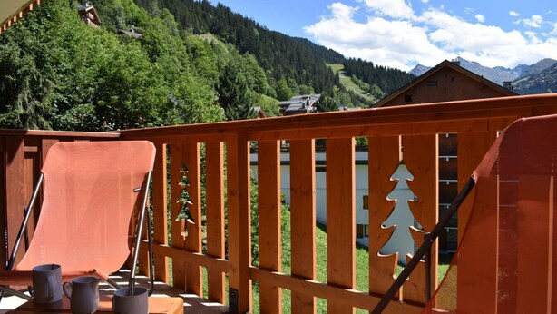 A wooden deck with a view of a forested mountain range. - 100m from resort center, 2nd floor, tv, 24m², Méribel (Méribel - Les Allues)