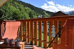 A wooden deck with a view of a forested mountain range. - 150m from ski slopes, 2nd floor, tv, 24m², Méribel (Méribel - Les Allues)
