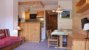 A compact living space with a kitchenette, a dining area, and a sofa. - 100m from resort center, 2nd floor, tv, 24m², Méribel (Méribel - Les Allues)