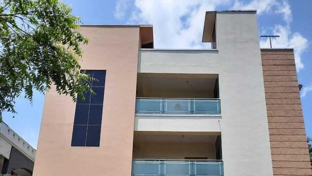Un edifici de diverses plantes amb un cartell que diu "GanEsha Mansion" i "Silver Villa".