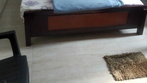 Un dormitori amb un llit, un armari i una petita catifa.