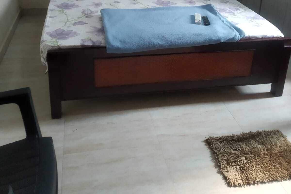 Een slaapkamer met een bed, een kledingkast en een kleed.