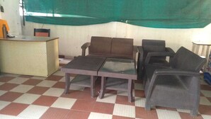 Una habitació amb un terra de petxines, un escriptori, dues cadires i una taula.