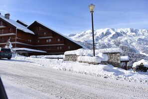 Un edificio cubierto de nieve con un muro de piedra y un farol.