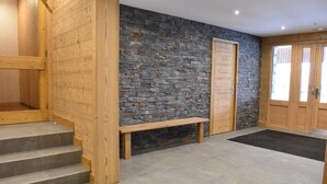 Una escalera de madera que conduce a un muro de piedra con un banco.